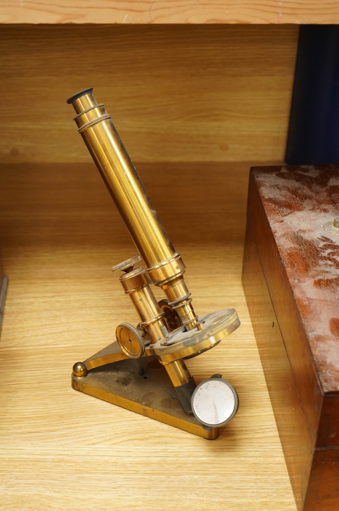 A late 19th century brass compound monocular microscope, by R and J. Beck, mahogany cased, with two objectives, 2 eyepieces and miscellaneous slides, the case dimensions; 40.5 x 15.5x 18cm, together with a small early 19